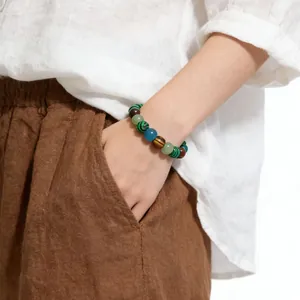 Detailed macro shot of natural stone beaded bracelet featuring tiger eye and malachite stones