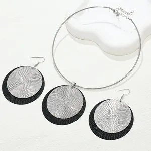 Vista detallada de conjunto de joyas geométricas de discos metálicos con textura espiral