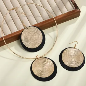 Primer plano de un conjunto de joyas vintage de discos dorados y negros sobre una bandeja.