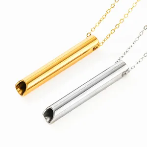 Detailed close-up showing gold and silver titanium steel meditation whistle necklaces
