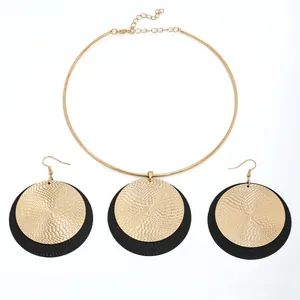Conjunto de joyas vintage con discos texturizados dorados y negros, collar y pendientes
