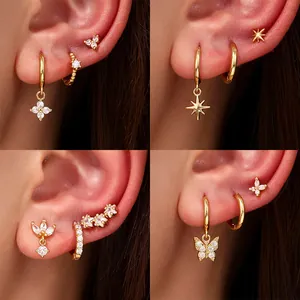 Close-up of gold-plated earring set with zircon butterflies, stars, and floral motifs.