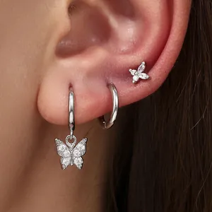 Detailed close-up view of elegant silver butterfly hoop earrings set on a model ear