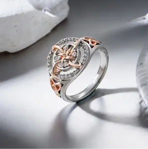 Detail of a two-tone silver and rose gold ring with intricate Celtic knot design