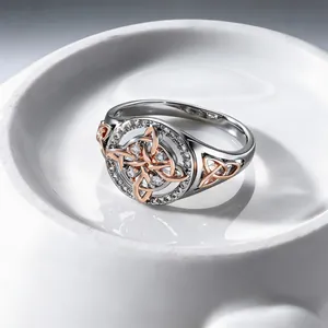 Macro view of a two-tone silver and rose gold Celtic knot ring featuring clear zircon accents