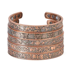 Detailed view of antique copper magnetic therapy bracelets with floral and butterfly patterns