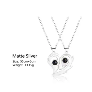 Detail of matte silver magnetic heart couples pendant projection necklace