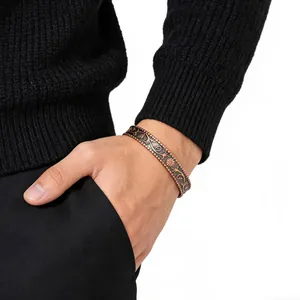 Close-up of vintage antique red copper flower pattern magnetic cuff bracelet on male wrist