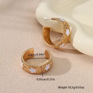 Vue détaillée montrant le diamètre de 2,4 cm de ces boucles d'oreilles dorées