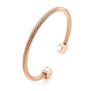 Detailed macro view of rose gold twisted cable magnetic cuff with polished end caps