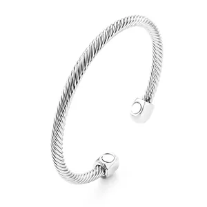 Macro view of silver twisted cable magnetic bangle showing intricate wire texture