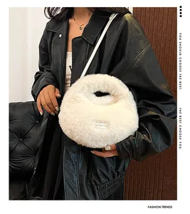 Bolso bandolera de peluche blanco tipo dumpling combinado con chaqueta de cuero negro.