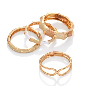 Detailed view of golden enamel bangle set featuring marble patterns and engravings