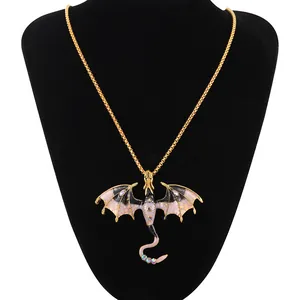 Detail of a vintage flying dragon pendant with beige enamel wings and crystal accents.