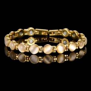 Dettaglio macro di un elegante bracciale dorato con pietre occhio di gatto e magneti