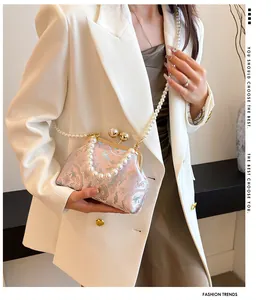 Primo piano di un'elegante borsa ricamata rosa con manici in perle e tracolla