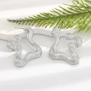 Macro view of silver wavy flower earrings featuring a unique grooved stripe texture