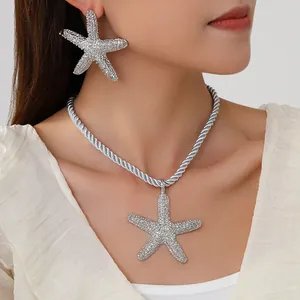 Close-up of sparkling silver starfish pendant necklace and matching stud earrings