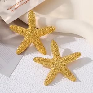 Close-up detail of textured gold starfish stud earrings for elegant beach jewelry