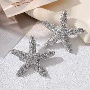 Macro view of textured silver starfish earrings with a shimmering hammered finish detail
