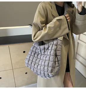 Silver quilted bubble tote bag shown worn with a beige trench coat