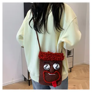 Detailansicht einer lustigen gehäkelten Cartoon-Handytasche mit sehr großen Augen
