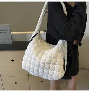 White quilted puffer tote bag with bubble texture carried by model in casual setting
