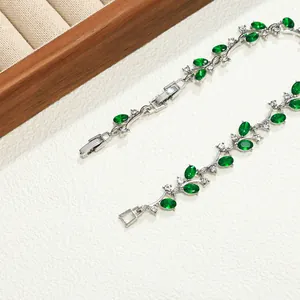 Detailweergave van zilveren takarmband met smaragdgroene marquise strass-steentjes