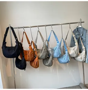 Variety of colorful nylon crescent crossbody bags hanging on a display rack for everyday use