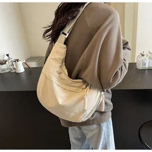 Detailed view of cream canvas dumpling bag with braided zipper pulls for daily commute