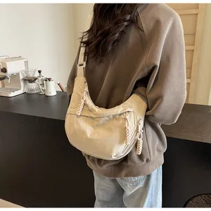 Detailed back view of a casual beige crescent dumpling crossbody bag on a model