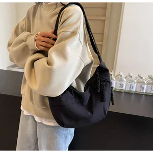 Close-up of black crescent dumpling bag worn by model for casual commuting daily style.