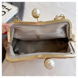 Detail view of the elegant chevron lining and interior pocket of a gold clutch bag