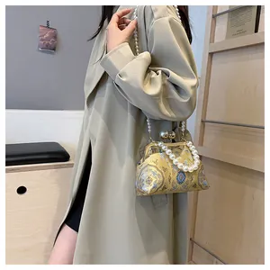 Vista dettagliata dell'elegante borsa ricamata con manico e tracolla in perle decorative