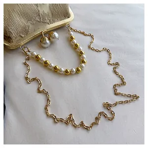 Detail view of stylish new Chinese style clutch with pearl beads and gold chain strap