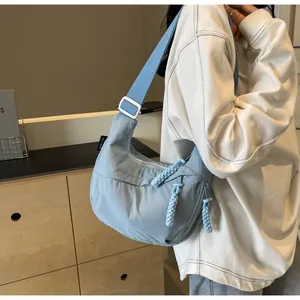 Detailed view of a light blue casual dumpling crescent shoulder bag on a model