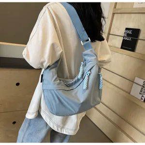 Casual light blue dumpling crossbody bag for women, back view showing strap and large capacity.