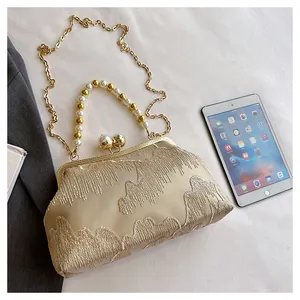 Detailed view of champagne beaded handbag with elegant embroidery and gold chain strap