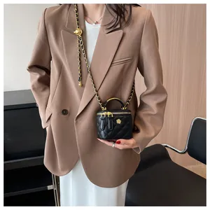 Chic black quilted chain box bag paired with a brown blazer for a stylish summer outfit