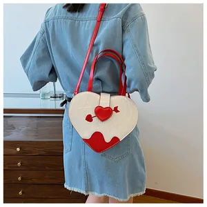 Fashionable white heart-shaped handbag with red Cupid's arrow detail on denim model back.