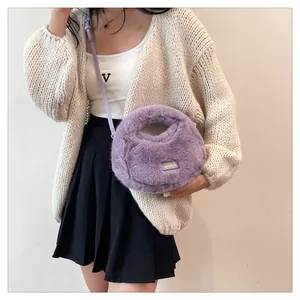 Modelo llevando un lindo bolso bandolera de peluche morado con acabado de piel sintética.
