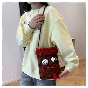 Handgefertigte, lustige Monster-Häkeltasche für Handys, am Modell präsentiert