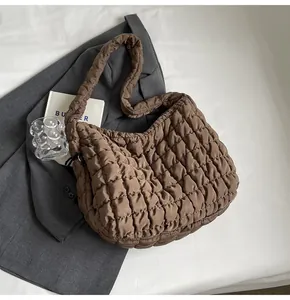 Close-up of the stylish brown quilted bubble tote bag placed on a professional gray blazer