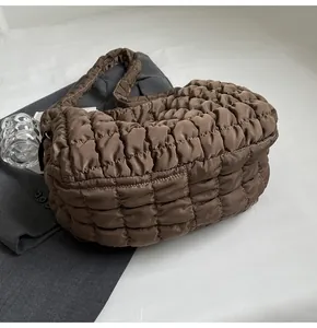 Detailed view of brown quilted puffy shoulder bag with bubble texture and soft padding
