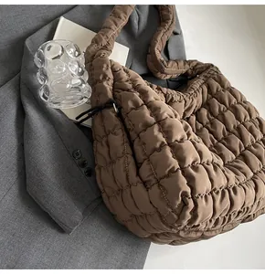 Detailed view of large brown puffer tote bag with bubble quilted texture