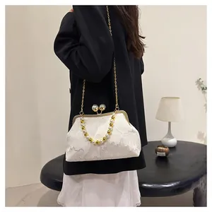 Elegant New Chinese style beaded white floral frame handbag worn as crossbody bag.