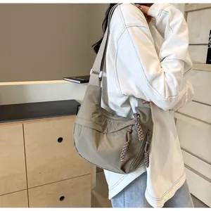 Close-up of khaki dumpling bag crossbody style on model for daily commute