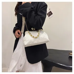 Elegant white textured clasp handbag with decorative pearl handle and gold chain detail
