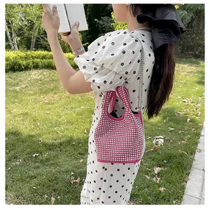 Detailed view of a sparkling pink rhinestone bucket bag with elegant silver chain strap