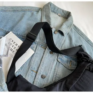 Close-up detail shot of a stylish black nylon dumpling bag with adjustable wide strap